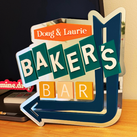 Decorative sign for a home bar on a wooden surface.