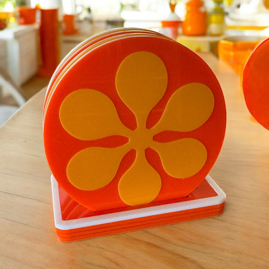 Set of orange retro coasters with a floral design on a wooden surface