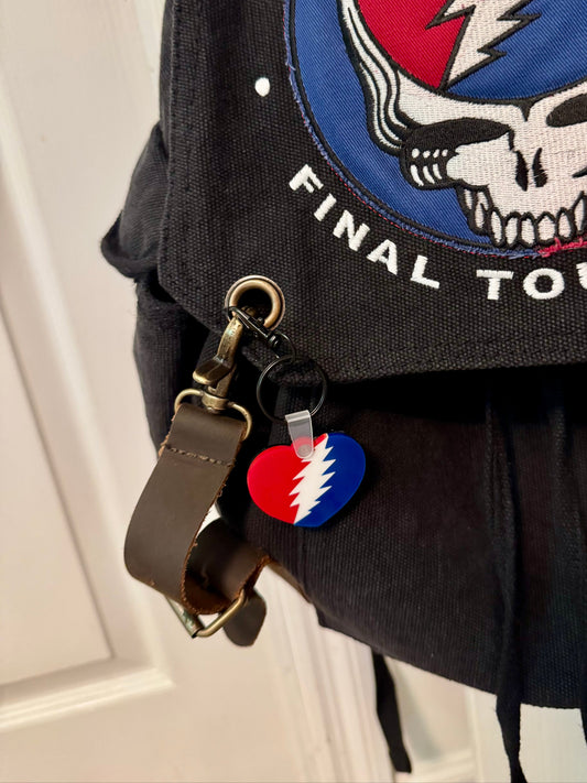 Black backpack with Grateful Dead logo and 'Final Tour' text, featuring a keychain with a similar design.