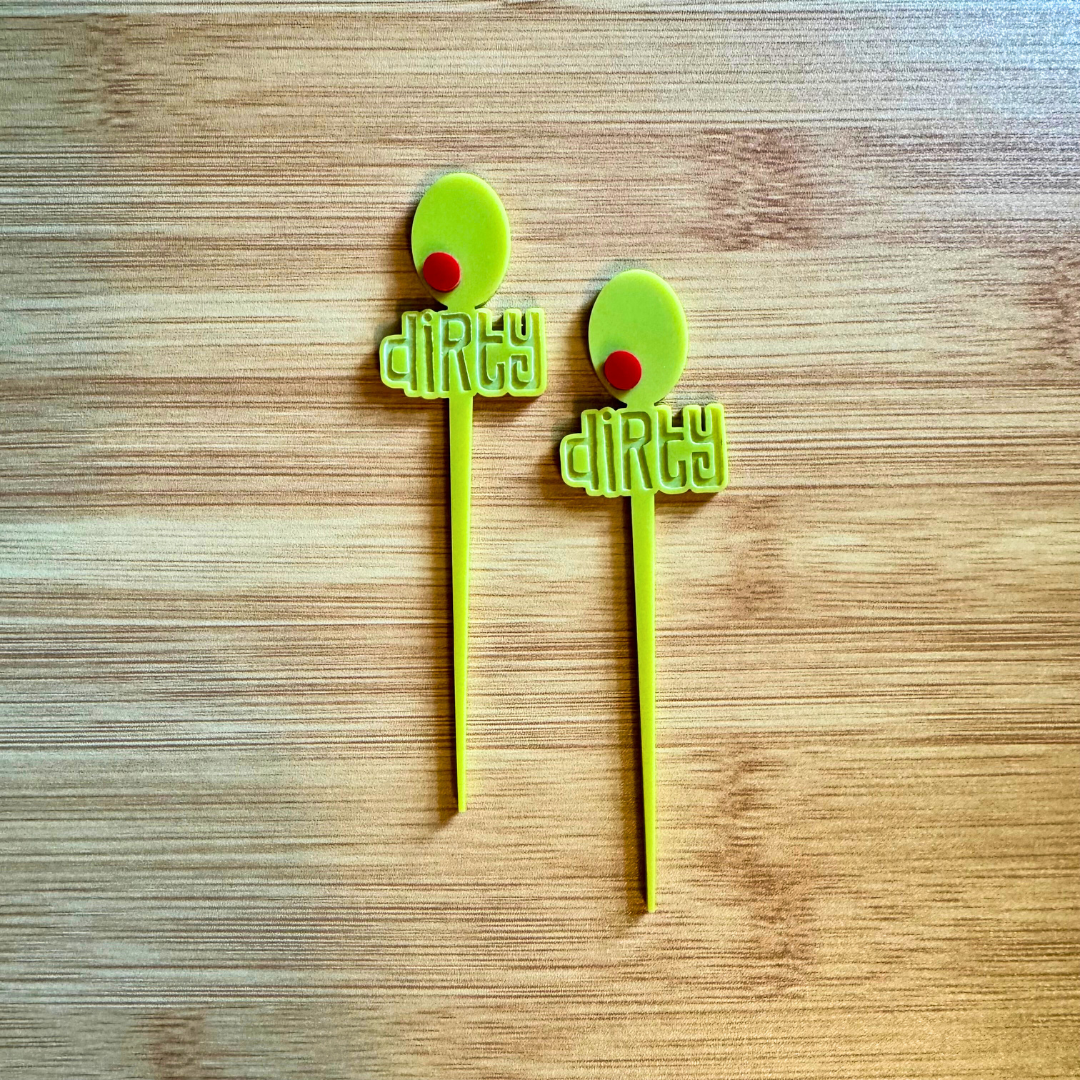 two cocktail picks with green olive design, red pimento, and the word dirty engraved