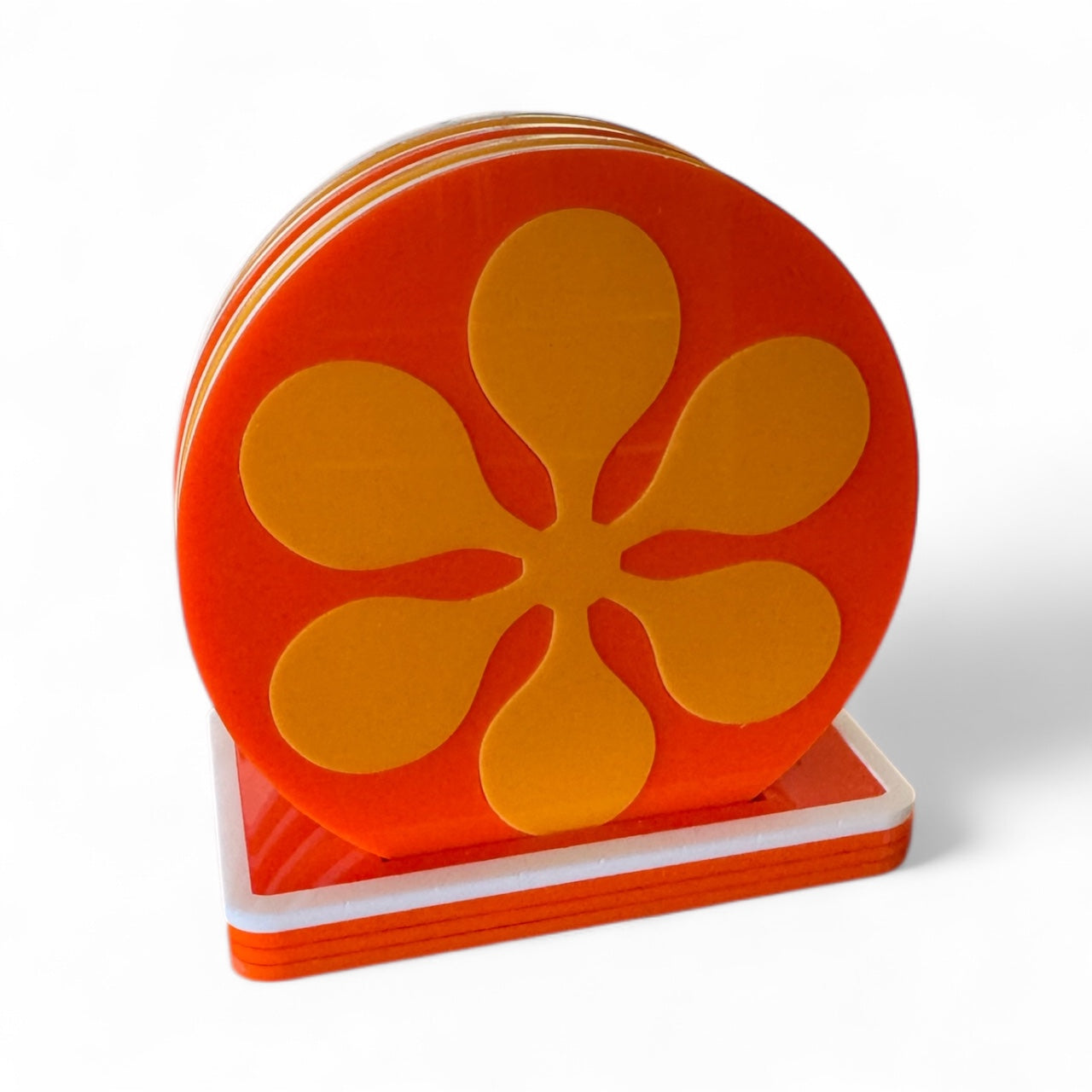 Set of orange retro flower-shaped coasters on a white background