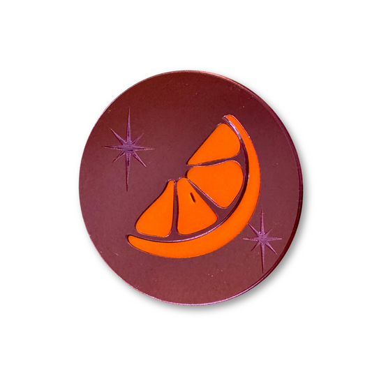 an orange slice inlaid in pink mirror acrylic