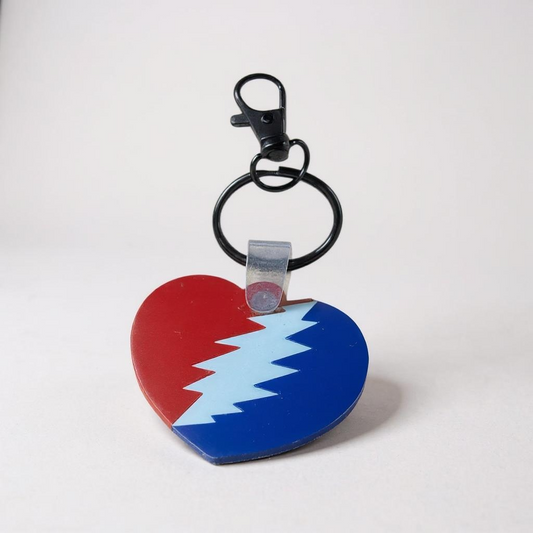 Heart-shaped keychain with red, blue, and white design on a white background